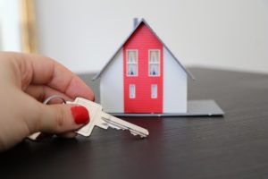 Maison miniature avec une main tenant une clé