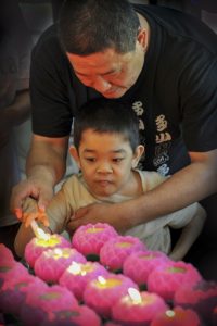 Homme aidant enfant autiste à allumer des bougies