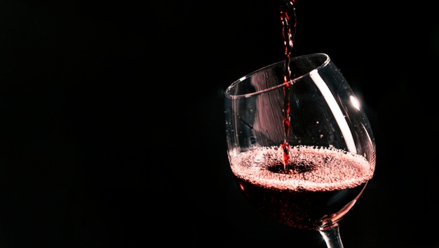 verre de vin rouge en train d'être rempli