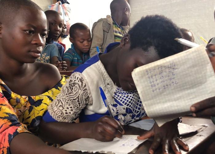 Enfants accompagnés de leur parents dans une école de zone de conflits