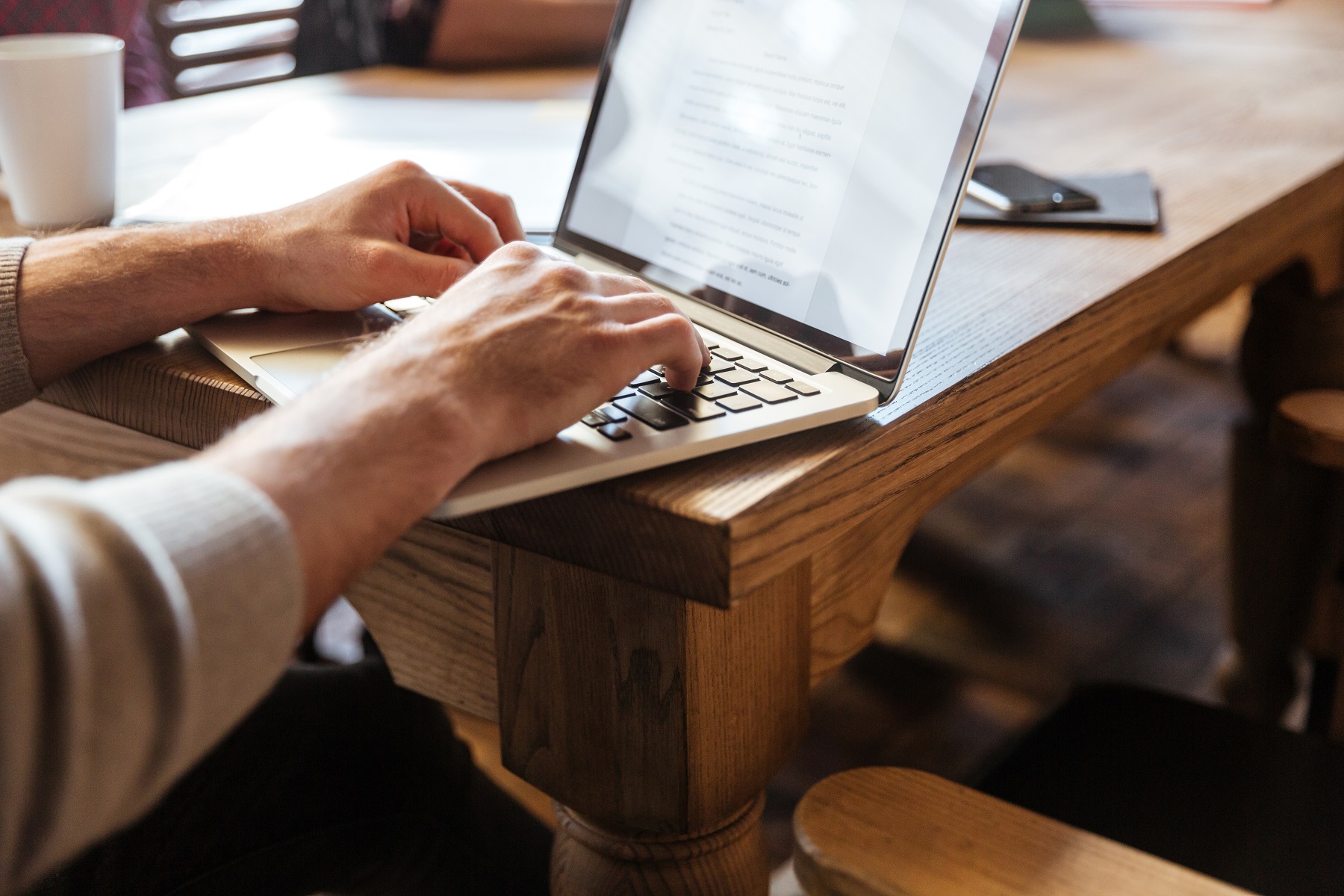 Main d’un homme en train de travailler sur un ordinateur portable