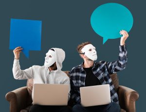 Deux personnes masquées avec des ordinateurs portables tenant des bulles de dialogue.