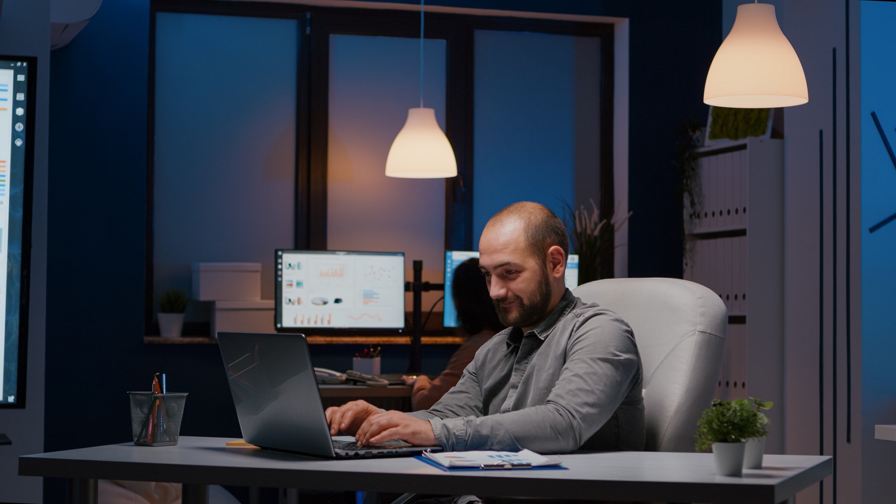 Homme d’affaires vérifiant les statistiques sur un ordinateur portable dans le bureau d’une entreprise