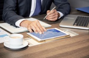 Un homme d'affaires qui utilise une tablette à table.