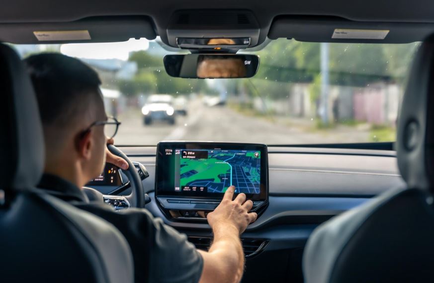 Un homme touche l'écran d'un système GPS dans une voiture