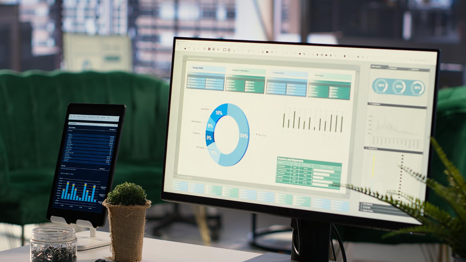Écran d'ordinateur et tablette affichant des graphiques financiers détaillés dans un bureau moderne.