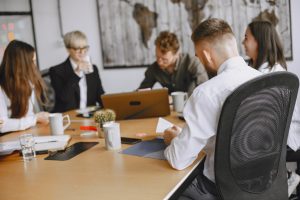 Une équipe de cinq jeunes professionnels est réunie autour d'une table ronde dans un bureau moderne