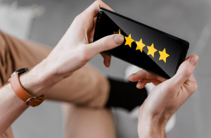 Une personne consulte ou attribue une note d'évaluation avec des étoiles jaunes sur un smartphone