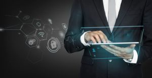 un homme d'affaires en costume utilisant une tablette numérique transparente affichant des icônes virtuelles