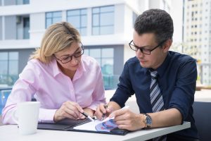 Un conseiller en gestion de patrimoine échange avec un client autour de solutions d’investissement et de placements financiers